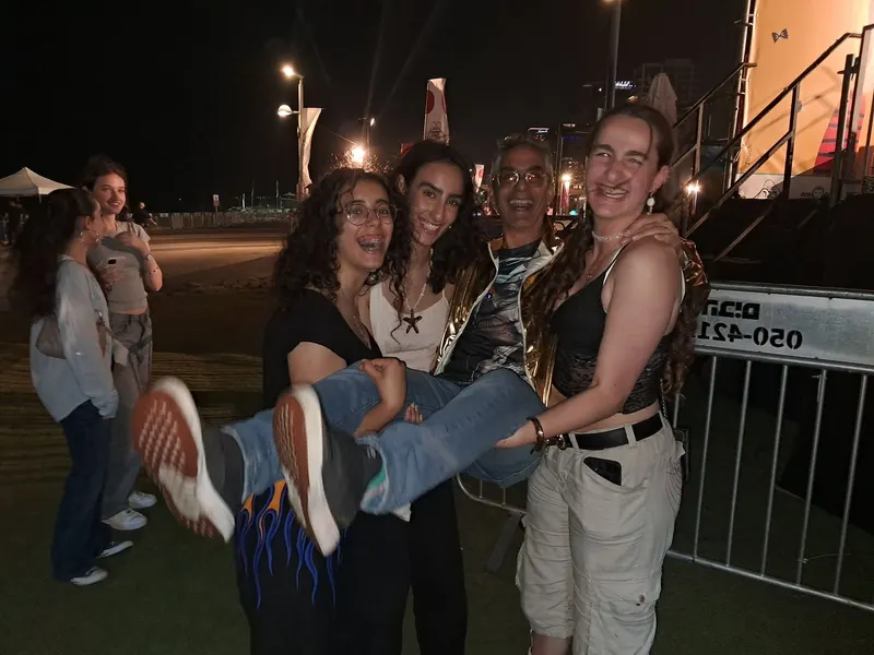 קהל צעיר ושמח חוגג ומצטלם עם חבר להקה אחרי ההופעה